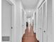 Hallway featuring hardwood floors and several closet doors on each side at 30 Pinetree Ct, Palm Harbor, FL 34683