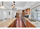 Bright kitchen featuring granite countertops, wood cabinets, stainless appliances, and hardwood floors at 30 Pinetree Ct, Palm Harbor, FL 34683