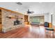 Living room with brick fireplace, hardwood floors, built-in shelves, and lots of natural light at 30 Pinetree Ct, Palm Harbor, FL 34683