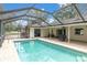 Inviting screened-in pool area with brick patio and plenty of space for outdoor entertaining at 30 Pinetree Ct, Palm Harbor, FL 34683