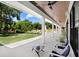 The covered back porch boasts outdoor seating and views of the green yard and swimming pool at 3440 Crenshaw Lake Rd, Lutz, FL 33548