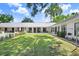 Expansive backyard with a well-maintained lawn, leading up to the home's modern exterior at 3440 Crenshaw Lake Rd, Lutz, FL 33548