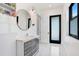 A well-lit bathroom with white marble floors, a vanity, a stylish mirror, and built-in storage at 3440 Crenshaw Lake Rd, Lutz, FL 33548