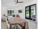 A bonus room with a large table, seating, a mounted television, and black-framed windows at 3440 Crenshaw Lake Rd, Lutz, FL 33548