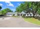 Stately home exterior with a circular driveway, manicured lawn and mature trees create a welcoming entrance at 3440 Crenshaw Lake Rd, Lutz, FL 33548