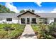 Charming exterior showcasing a landscaped front yard and modern farmhouse design at 3440 Crenshaw Lake Rd, Lutz, FL 33548