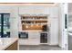 Modern kitchen features white cabinets, beverage center, built in oven, and coffee bar area at 3440 Crenshaw Lake Rd, Lutz, FL 33548