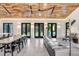 Open-concept living room with hardwood ceiling, ample seating and large windows at 3440 Crenshaw Lake Rd, Lutz, FL 33548