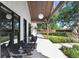 A covered patio with lounge chairs invites relaxation while overlooking the manicured lawn and garden at 3440 Crenshaw Lake Rd, Lutz, FL 33548