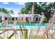Secluded pool area with lush landscaping and a view of the home's modern exterior through ornamental grasses at 3440 Crenshaw Lake Rd, Lutz, FL 33548