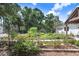 The beautiful landscaped yard has lush greenery, blooming flowers, and detached garage at 3440 Crenshaw Lake Rd, Lutz, FL 33548
