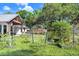 A charming single-story home with a metal roof overlooks the lush garden and raised garden beds at 3440 Crenshaw Lake Rd, Lutz, FL 33548