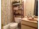 Bathroom showing toilet, curtained shower/tub, and decorative shelves, creating a cozy and practical space at 3505 Tarpon Woods Blvd # P408, Palm Harbor, FL 34685