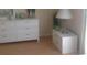 Bedroom showing white dresser, a nightstand with a lamp, and a view of the light colored flooring at 3505 Tarpon Woods Blvd # P408, Palm Harbor, FL 34685