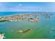 Picturesque aerial view of waterfront properties and a sandy beach stretching along the coastline under a partly cloudy sky at 365 La Hacienda Dr, Indian Rocks Beach, FL 33785