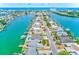 Stunning aerial view of canal-front homes, each with boat docks, leading to the ocean and distant high-rise buildings at 365 La Hacienda Dr, Indian Rocks Beach, FL 33785