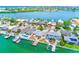 Overhead view of waterfront homes with boat docks along canals, showcasing tropical landscaping and boat access at 365 La Hacienda Dr, Indian Rocks Beach, FL 33785