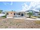Welcoming home featuring a covered patio, mature landscaping, and private walkway at 365 La Hacienda Dr, Indian Rocks Beach, FL 33785