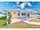 Back exterior view of the home with a covered patio and landscaping with an exterior wall decoration at 365 La Hacienda Dr, Indian Rocks Beach, FL 33785
