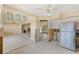 Open concept kitchen needing remodel with stainless steel refrigerator and tile floors. Plenty of natural light at 365 La Hacienda Dr, Indian Rocks Beach, FL 33785