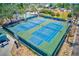 Aerial view of the fenced tennis courts with blue and green surface with well-maintained surroundings at 365 La Hacienda Dr, Indian Rocks Beach, FL 33785