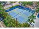 Aerial view of fenced tennis courts with blue and green surface, surrounded by lush greenery at 365 La Hacienda Dr, Indian Rocks Beach, FL 33785