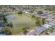 An aerial shot of a residential neighborhood surrounding a green lake on a sunny day at 4014 Pleasant Ridge Dr, New Port Richey, FL 34652