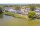 Aerial view of backyard featuring a lake view, screened-in porch, and lush greenery at 4014 Pleasant Ridge Dr, New Port Richey, FL 34652