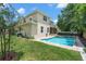 Beautiful backyard with a sparkling pool, lush lawn, and a screened patio area at 4206 W Sevilla St, Tampa, FL 33629