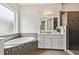 Elegant bathroom with a soaking tub, walk-in shower, and vanity with marble countertops and modern fixtures at 4206 W Sevilla St, Tampa, FL 33629