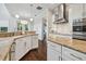 Bright kitchen with stainless steel appliances, white cabinets, dark hardwood floors and granite countertops at 4206 W Sevilla St, Tampa, FL 33629