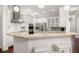 Modern white kitchen with stainless steel appliances, granite countertops, and counter seating at 4206 W Sevilla St, Tampa, FL 33629