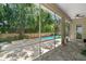 Screened-in patio area features a stone floor with views of the backyard pool and landscaping at 4206 W Sevilla St, Tampa, FL 33629