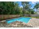 Backyard pool is surrounded by lush landscaping and a wooden fence for privacy at 4206 W Sevilla St, Tampa, FL 33629