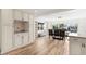 Spacious dining room with wood-look tile flooring, adjacent to a kitchen area with custom cabinets at 4425 13Th Ne Way, St Petersburg, FL 33703