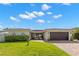 Charming single-story home with a red tile roof, a lush green lawn, and a brick driveway at 4425 13Th Ne Way, St Petersburg, FL 33703