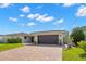 Well-maintained single-story home featuring a red tile roof, lush landscaping, and a dark brown garage door at 4425 13Th Ne Way, St Petersburg, FL 33703