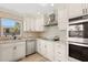 Well-lit kitchen showcases stainless appliances, mosaic backsplash, and custom white cabinets at 4425 13Th Ne Way, St Petersburg, FL 33703