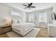 Bright main bedroom with hardwood floors, a ceiling fan, and natural light from two windows at 4757 Legacy Park Dr, Tampa, FL 33611