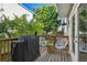 Outdoor deck with a grill, modern seating, and a view of the lush backyard at 4757 Legacy Park Dr, Tampa, FL 33611