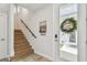 Bright entryway featuring an oak staircase, a modern front door, and neutral decor, creating a welcoming ambiance at 4757 Legacy Park Dr, Tampa, FL 33611