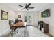 Well-lit office featuring a large desk, ceiling fan, TV, and access to the outdoor patio at 4757 Legacy Park Dr, Tampa, FL 33611