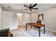 Home office with wood desk, ceiling fan, tile floors, and a view into the ensuite bathroom at 4757 Legacy Park Dr, Tampa, FL 33611