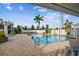 Relaxing community pool with lounge chairs, pergola, and clear water, surrounded by lush greenery and sunny skies at 4757 Legacy Park Dr, Tampa, FL 33611