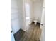 A bathroom with wood look tile flooring, and a toilet is connected to a closet at 5310 Companion Ln, Tampa, FL 33619