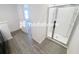 Modern bathroom with a sleek glass-enclosed shower and stylish wood-look flooring at 5310 Companion Ln, Tampa, FL 33619