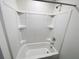 A bathtub in the bathroom is white with shelving for storage at 5310 Companion Ln, Tampa, FL 33619