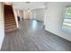 Open-concept living room showcasing wood-look floors, stairs, and plenty of natural light at 5310 Companion Ln, Tampa, FL 33619