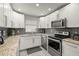 Modern kitchen featuring stainless steel appliances, granite countertops, and white cabinets at 6208 Rolling Hammock, Tampa, FL 33610