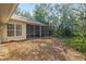 Landscaped backyard featuring the home's exterior and screened-in patio at 6237 Greenwich Dr, Tampa, FL 33647